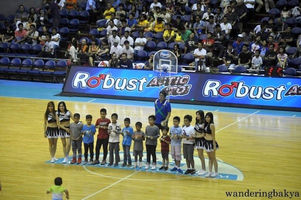 The kids who won in the shoot-tiny-ball-into-tiny-basket game. Obviously the name of the game is not that. 